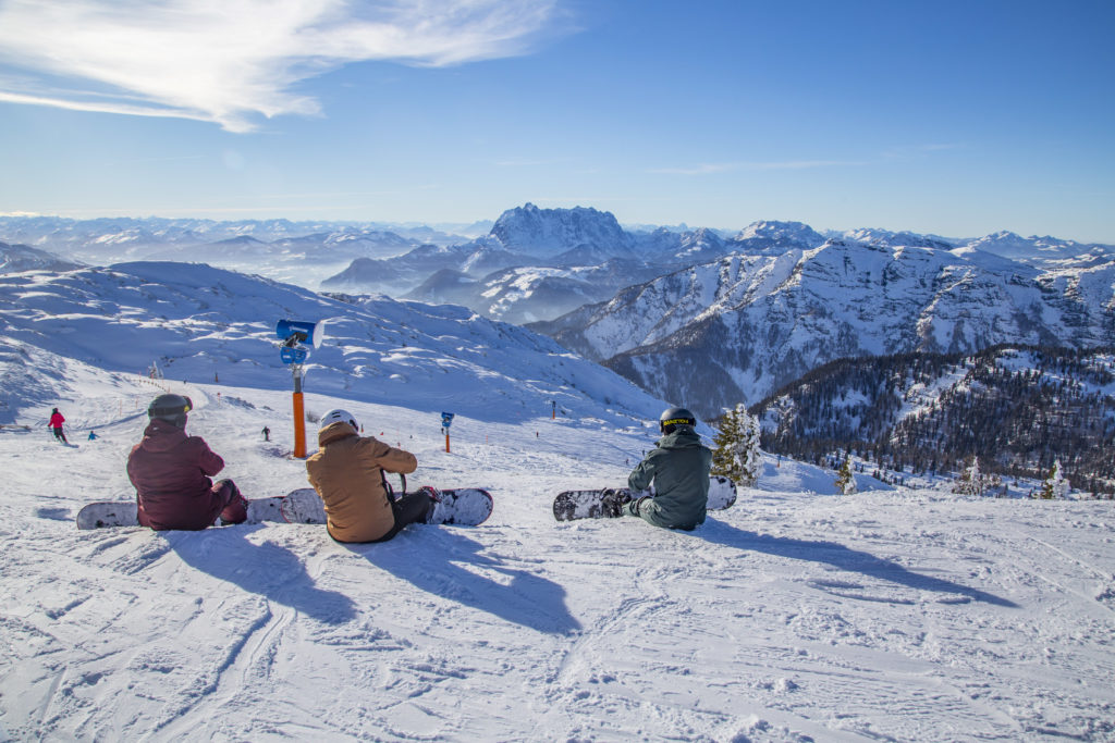 Snowboarder rasten am Gipfel, Skigebiet Steinplatte, hinten Wilder Kaiser